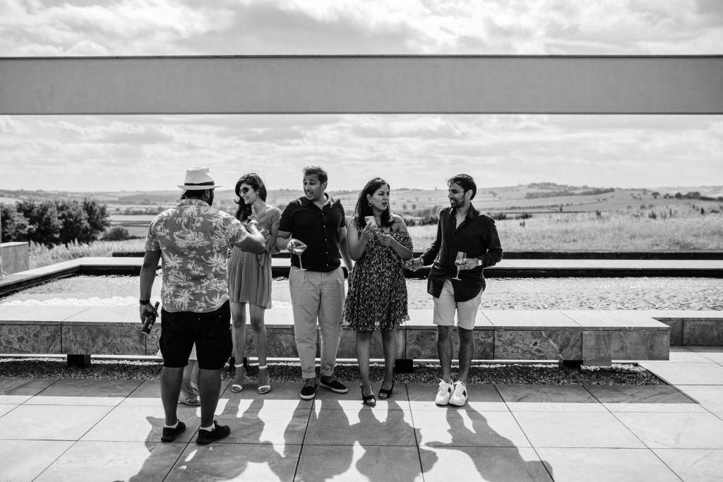 A black and white photo of a group of people embracing in front of a horizon.