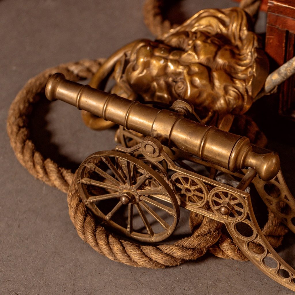 A bronze Lion's head, a canon on wheels and thick rope