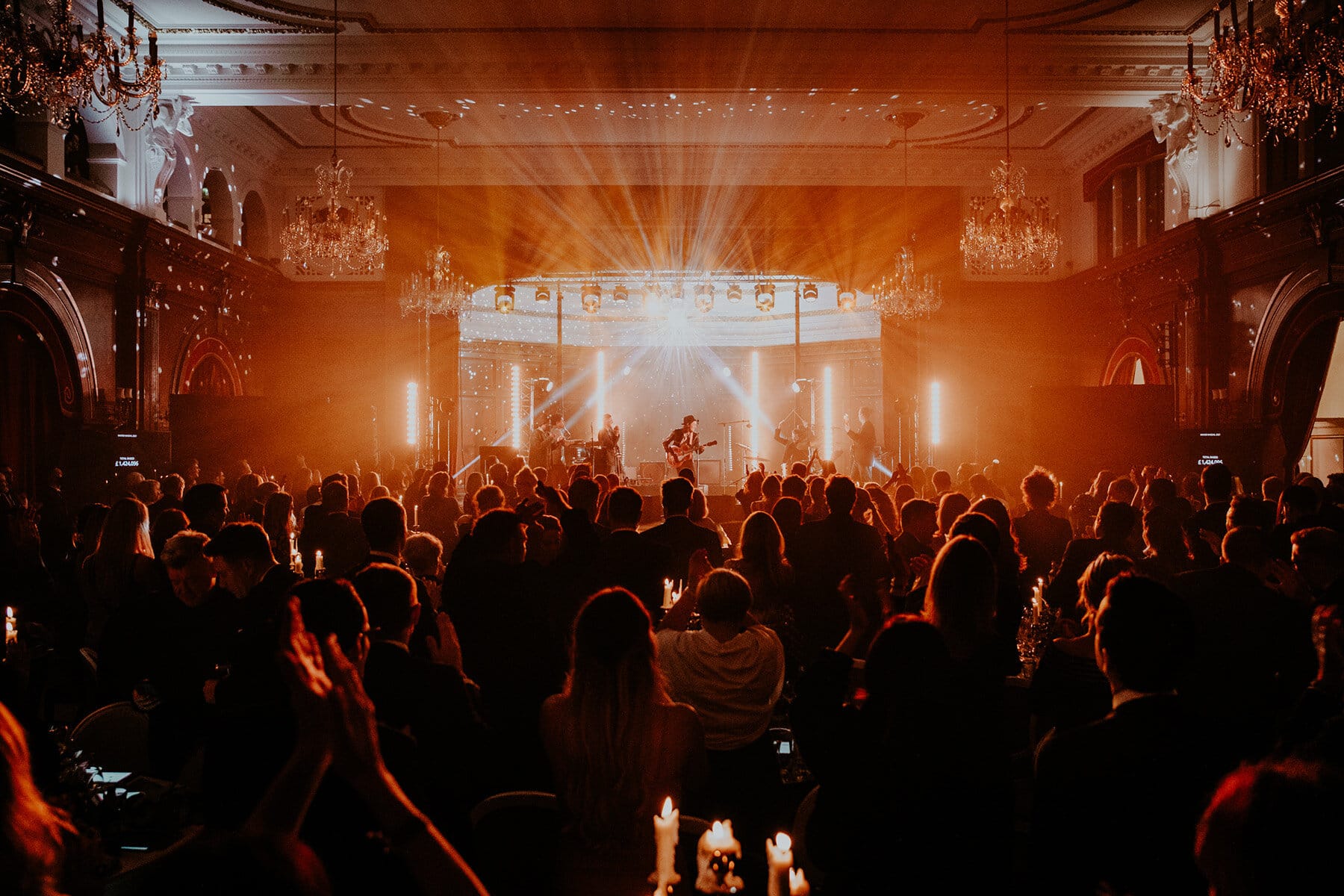 A stage lit in amber light with a crowd in the foreground.