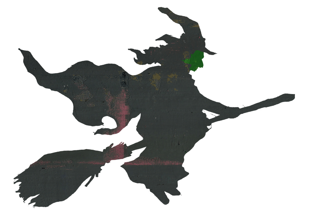 A witch with a green face dressed in black on a broomstick.