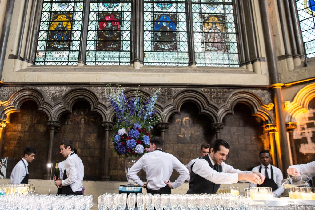 Waiters mixing cocktails in front of stained glass windows