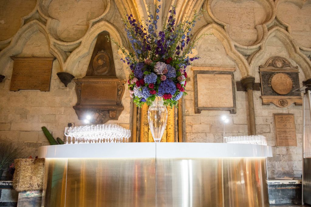 A gold cocktail bar with a tall floral centrepiece