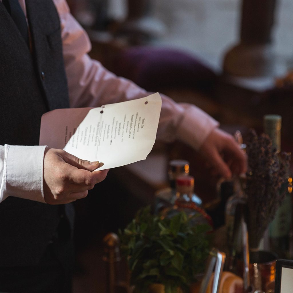 Person holding a piece of paper and choosing a bottle