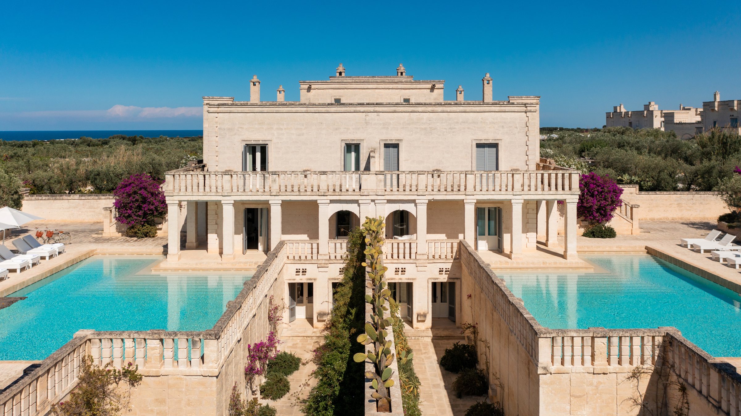 A stone house between two pools.