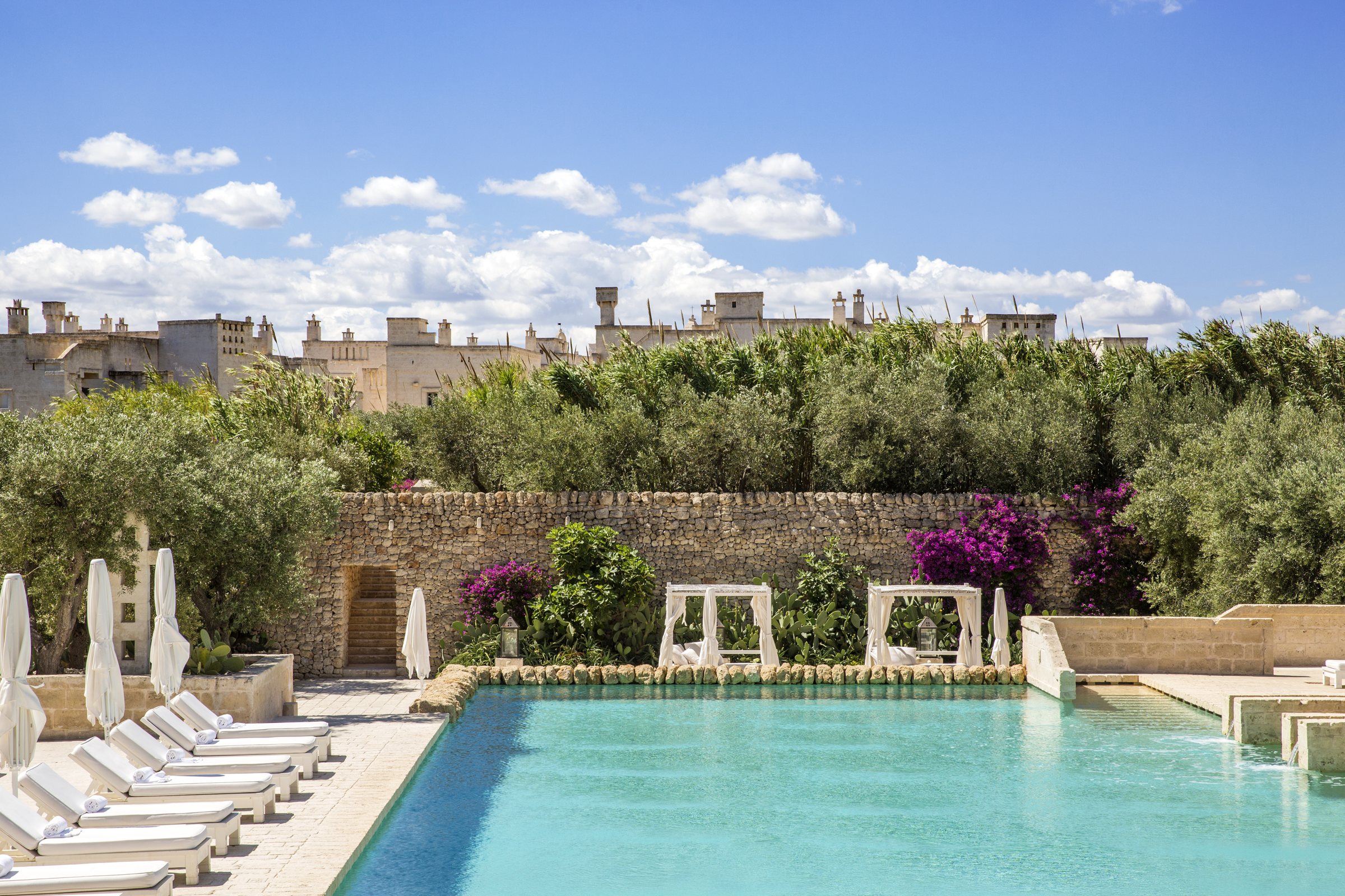 The pool at Borgo Egnazia, with its stone wall, olive trees and daybeds.