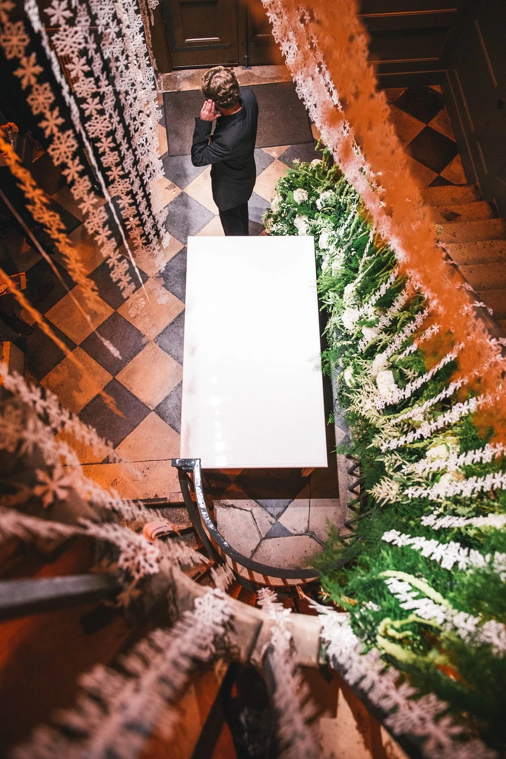 A garland of foliage and white flowers spiralling down the curved staircase at LSO St Luke’s.