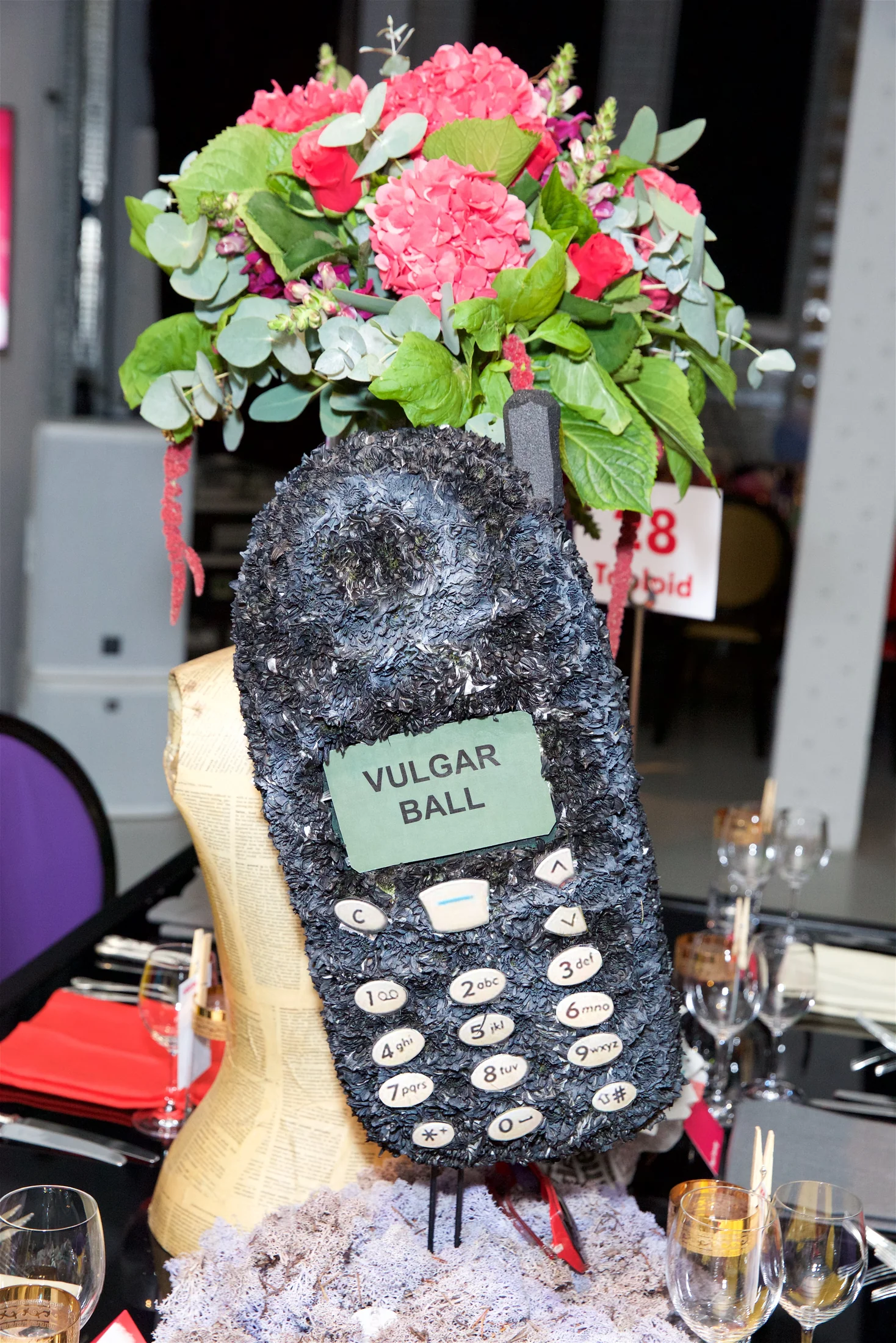 An oversized telephone built from floral materials standing on the yuppy table.