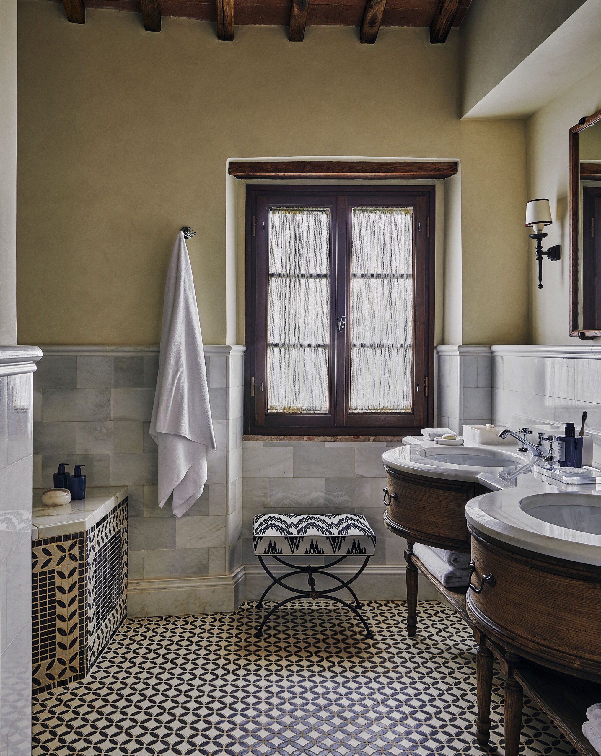 A suite bathroom with a patterned floor at Castello di Casole.