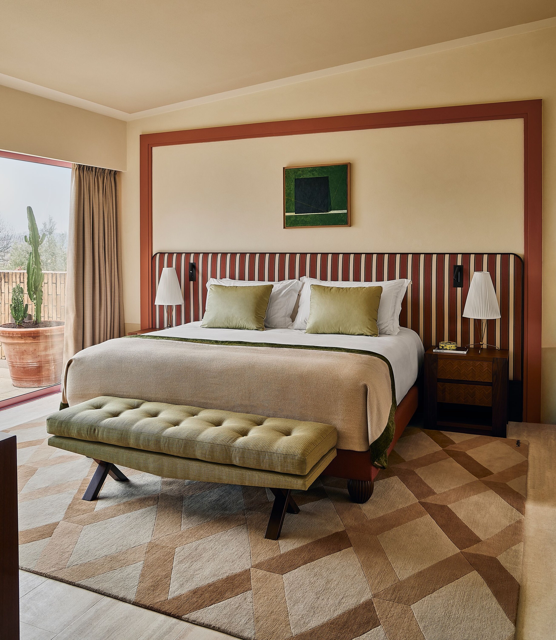 A suite bedroom with terracotta stripes at Castello di Casole.