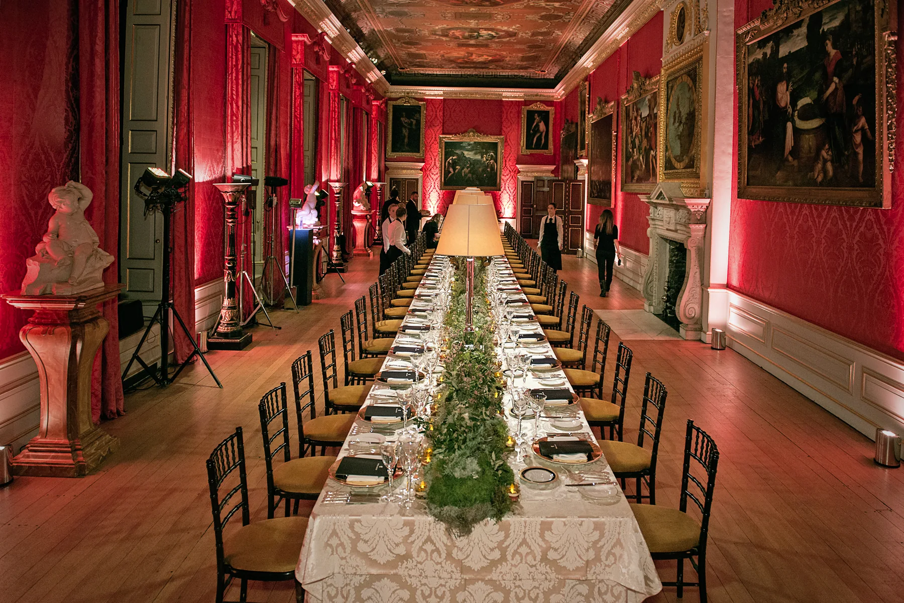 The whole gallery with the table running its full length beneath the paintings.