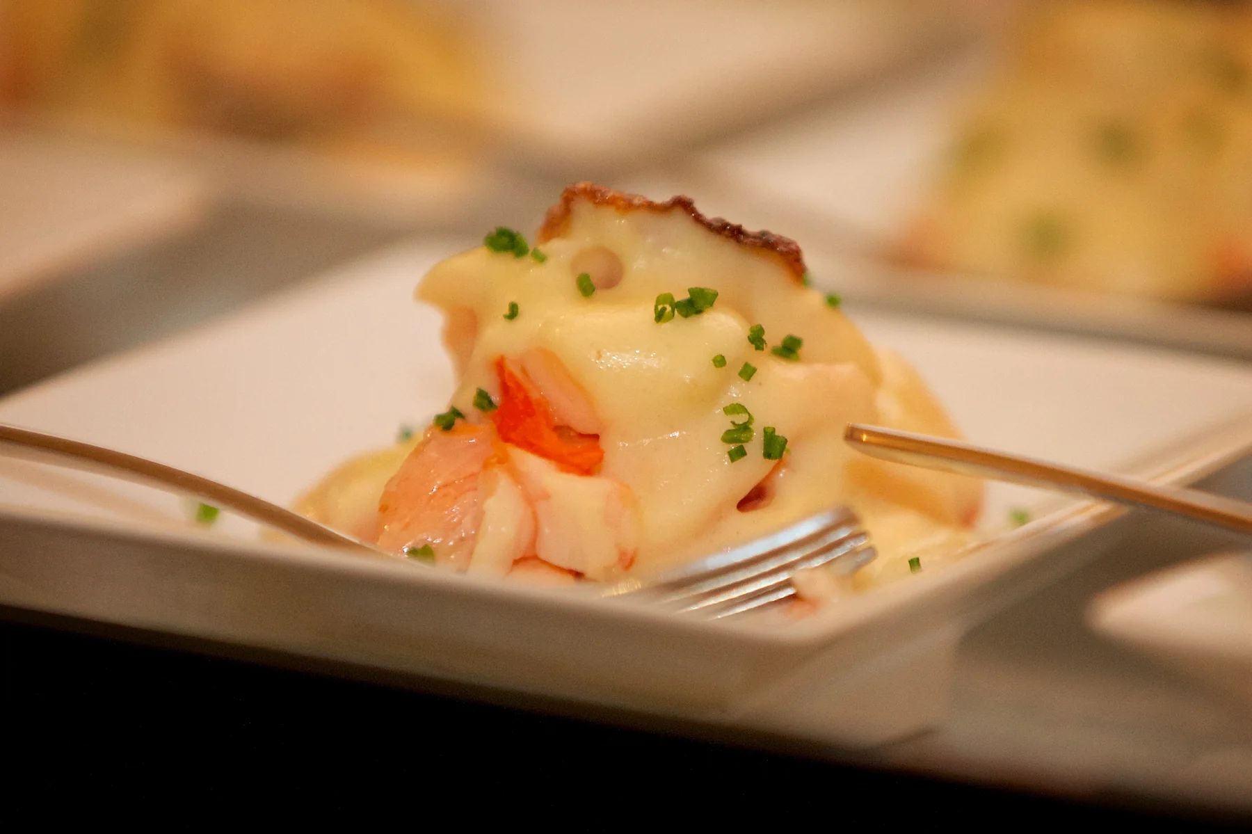 A canape set on a square white plate.