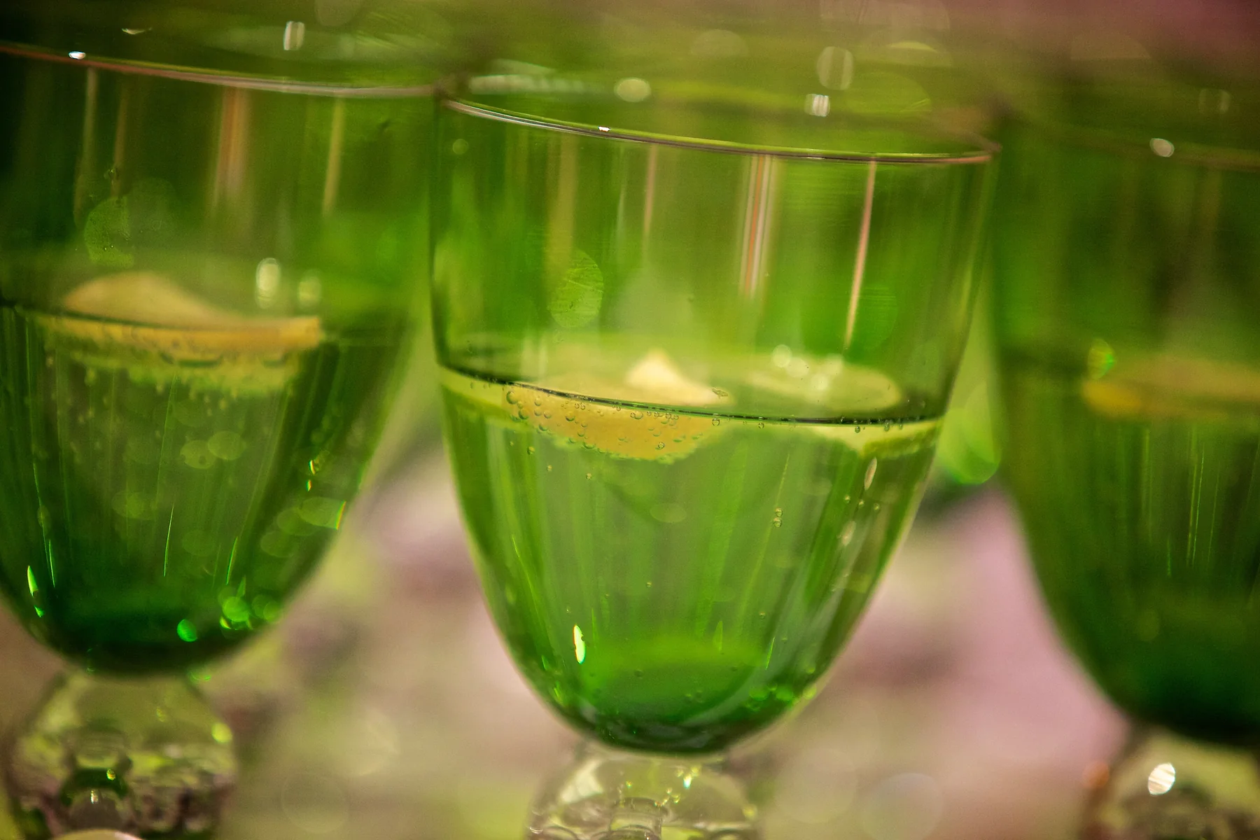 Green glass coupes filled and set out in a row.
