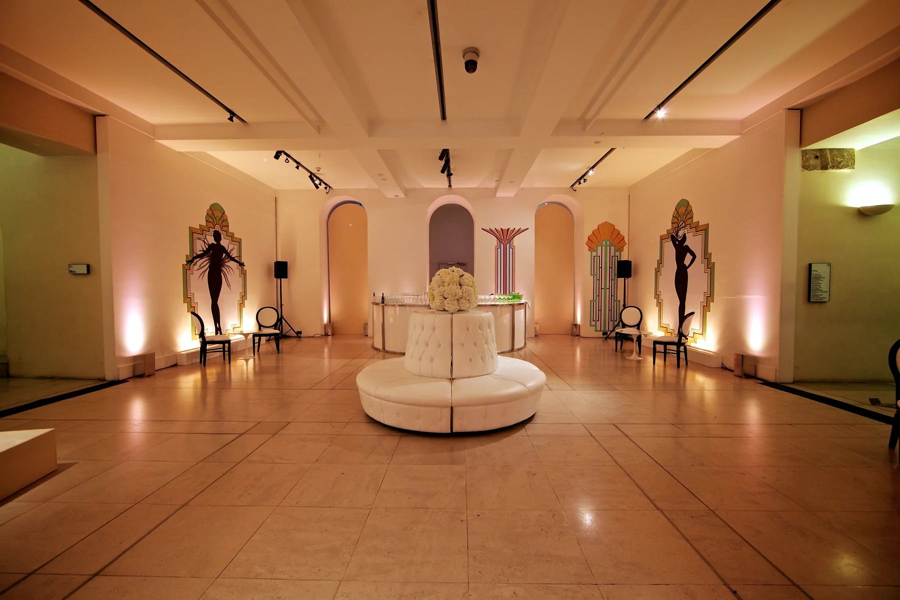 The same space empty before the build, bare floor and arched alcoves.